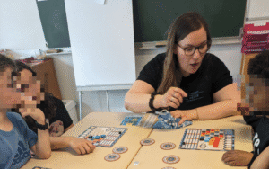 Stéphanie, bénévole d'À VAUX JEUX, anime un jeu lors d'une classe apprenante
